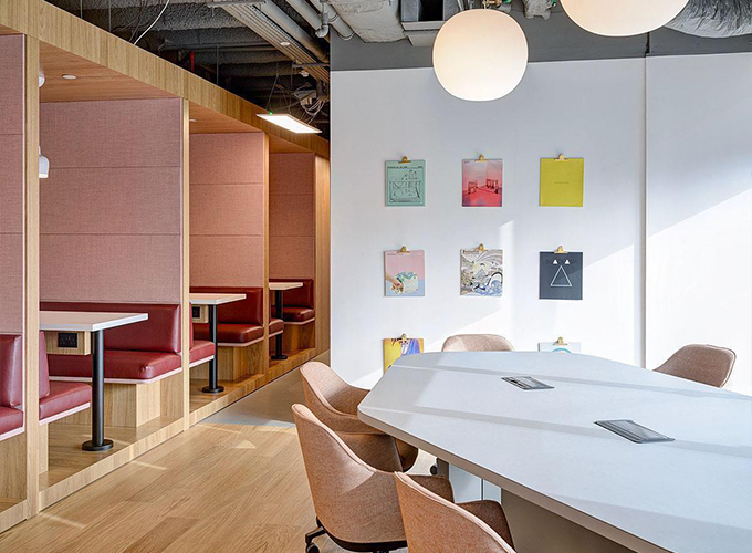 A room with tables and chairs, a wall of artwork.