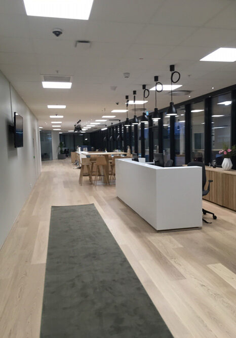 A long hallway with tables and chairs in it